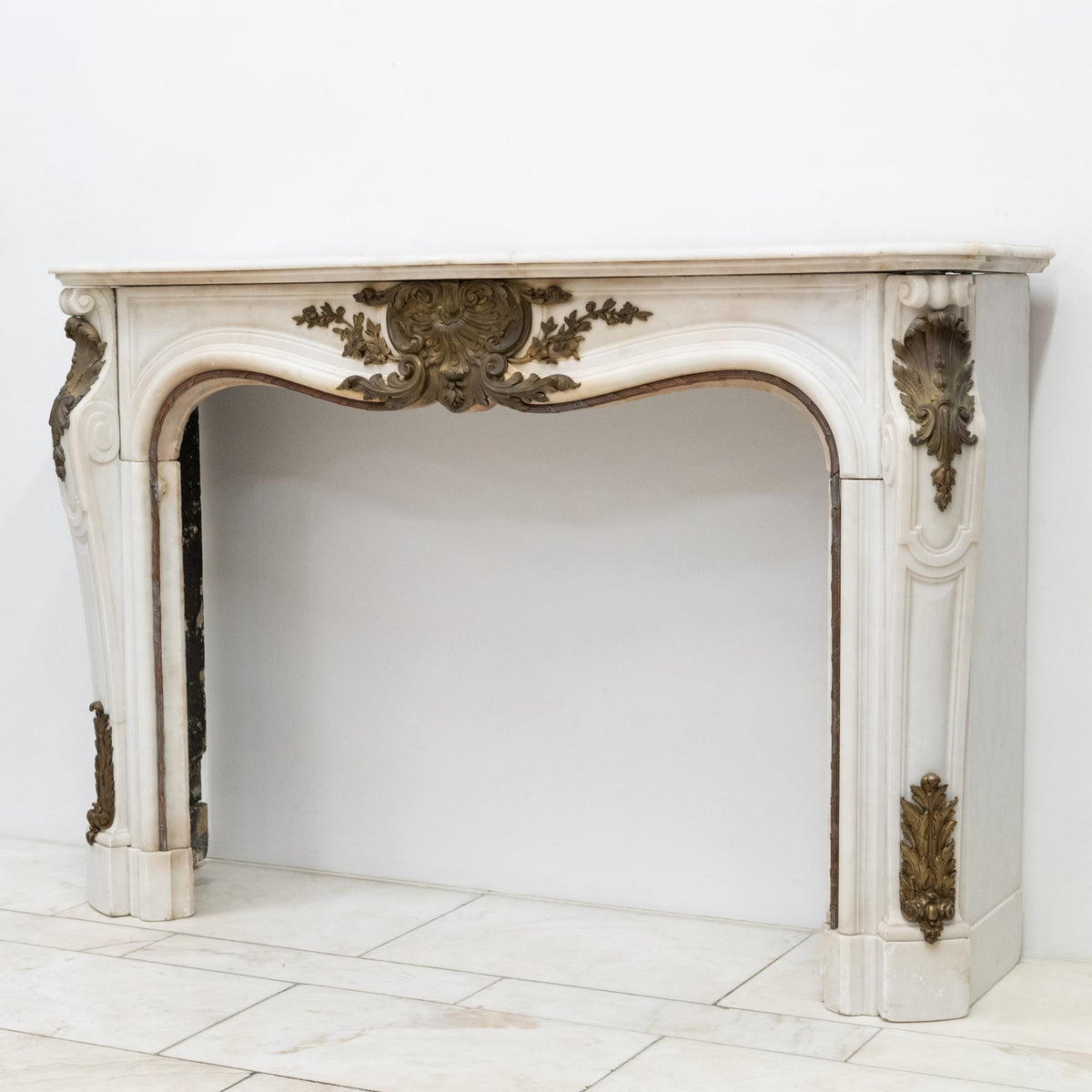 Antique French Louis XV Style Statuary Marble Fireplace with Brass Mounts | The Architectural Forum